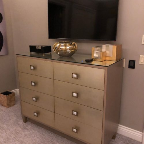 A dresser with drawers and a television on top of it.