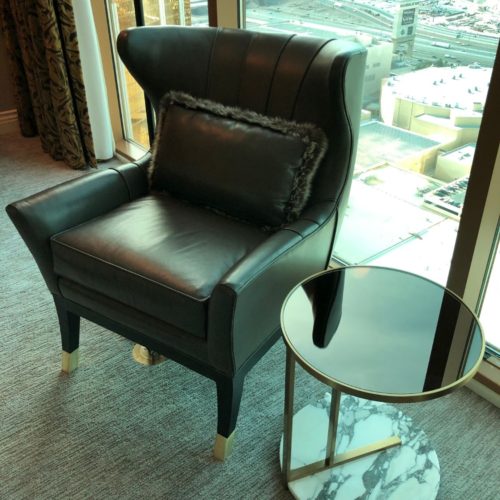 A black leather chair and table in front of a window.
