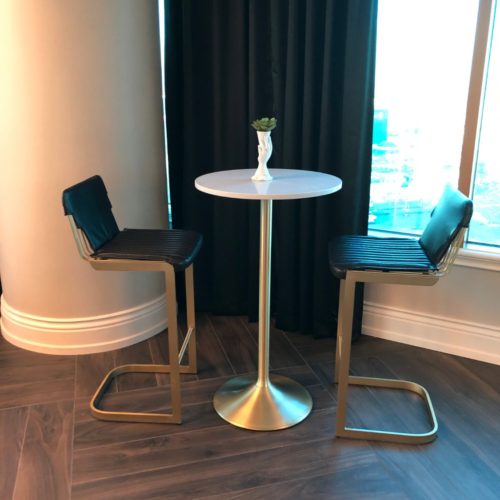 A table with two chairs and a vase on top of it.