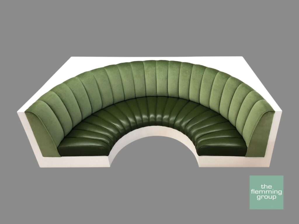 A green curved bench with white trim and a gray background.