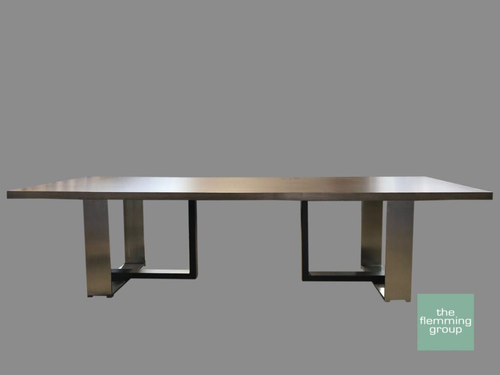 A long table with metal legs and a gray background