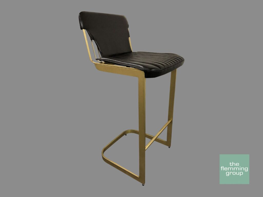 A black and gold bar stool with a grey background