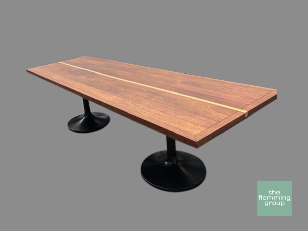 A table with two black metal legs and wooden top.