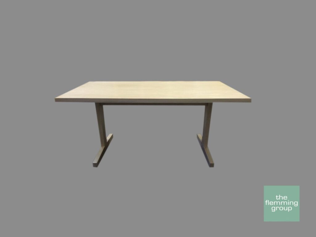 A table with two legs and one of the legs is missing.