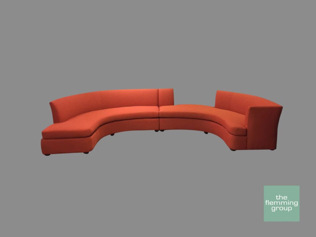 A red couch sitting on top of a gray floor.