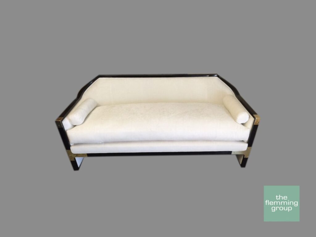 A couch with white fabric and black wood frame.