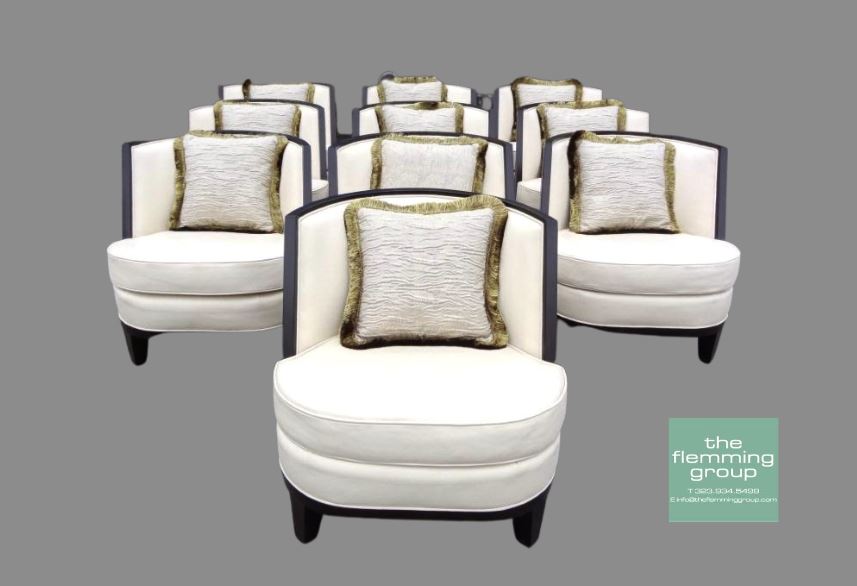 A group of ten white chairs with pillows.