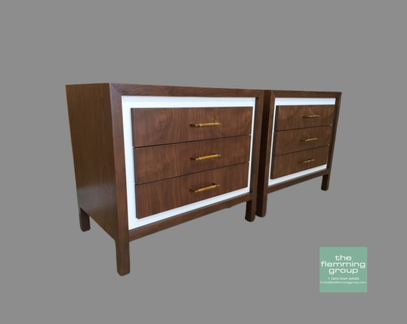A pair of nightstands with drawers and white trim.