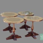 A set of four round tables with glass tops.